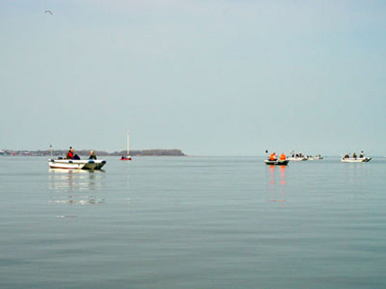 Blick übers Wasser, bei völliger Windstille und zahlreichen Angelbooten